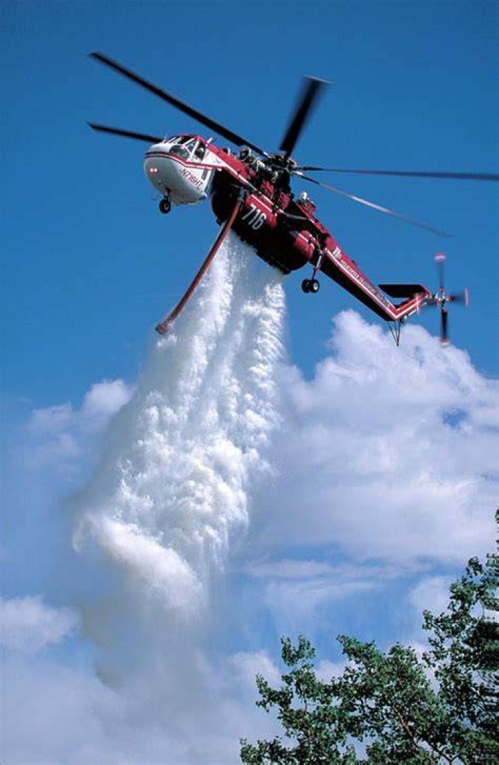 A helicopter drops water on the Rocky Fire in Lake County, California July 30, 2015. Photo by Max Whittaker/Reuters