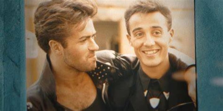 Andrew Ridgeley and George Michael, 1984 andrew ridgeley and george michael of the pop group wham, arriving at london airport george michael is wearing a choose life t shirt and holding a portable stereo 24th may 1984 photo by victor crawshawmirrorpixgetty images