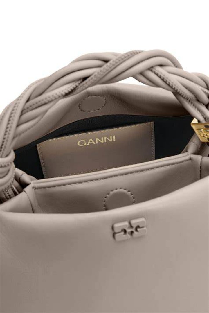 a woman holding a purse ganni bou bag
