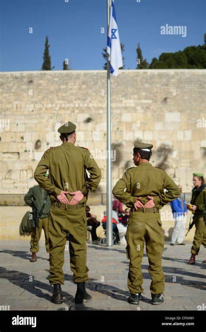 Israeli soldiers stand near to a tank near Israel's border with Lebanon in northern Israel